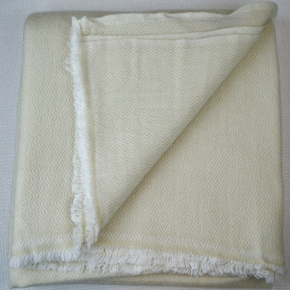 Folded white textured blanket on a light gray background